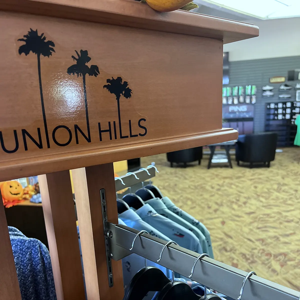Union Hills logo on a wooden apparel fixture